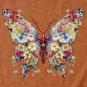 Gros plan de l'imprimé papillon fleuri sur la surface d'un t-shirt en maille caramel