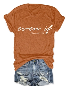 Flat lay of an orange cotton T-shirt with 'even if' text and distressed denim shorts