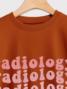 Detail of ribbed neckline and vertical radiology lettering on rust orange sweatshirt