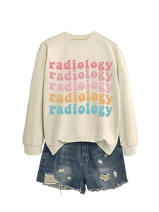 Detail of radiology colorful lettering on a cream sweatshirt with distressed denim shorts