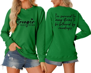 Front and back view of green crewneck sweatshirt with Stronger Than The Storm print