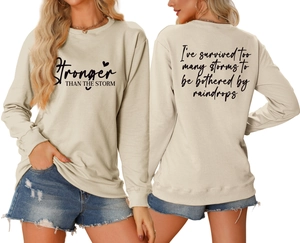 Front and back view of beige crewneck sweatshirt with Stronger Than The Storm print