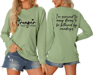 Detail view of double-sided print on light green sweatshirt with inspirational quotes