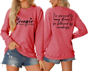 Front and back detail of pink sweatshirt with Stronger Than The Storm text print