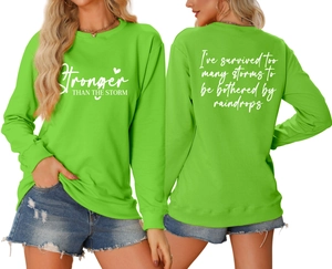 Front and back detail of green crewneck sweatshirt featuring white inspirational printing