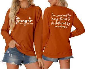 Detailed front and back view of burnt orange sweatshirt with white inspirational print
