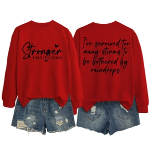 Detail view of red letter print sweatshirt and ripped denim shorts on white background