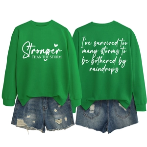 Front and back detail of green cotton sweatshirt with Stronger Than The Storm lettering