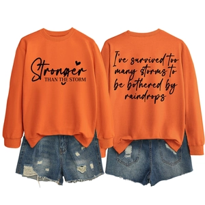 Detailed front and back view of orange sweatshirt with Stronger THAN THE STORM print