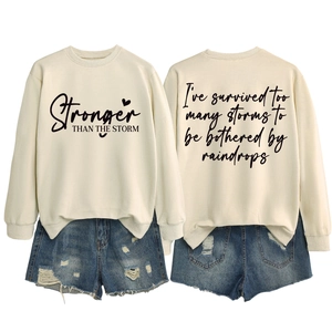 Front and back detail of cream sweatshirt with stronger than the storm typography
