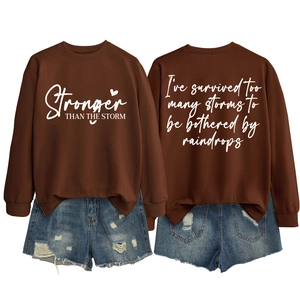 Flat lay of brown sweatshirt with white text prints and distressed denim shorts