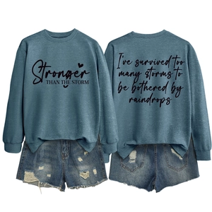 Detail of printed letter graphics and distressed denim shorts on casual blue sweatshirt