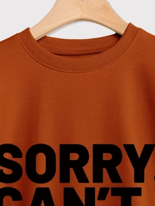 Detail eines karamellfarbenen Sweatshirts mit geripptem Rundhalsausschnitt und Print-Slogan