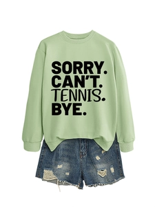 Detail eines hellgrünen Sweatshirts mit Spruch und zerrissenen Jeans-Shorts im Set