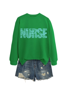 Detail of the green NURSE sweatshirt featuring medical typography and distressed denim shorts