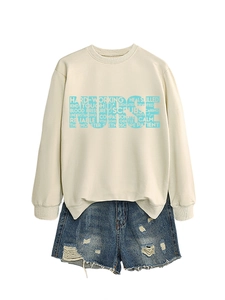 Detail of beige nurse sweatshirt with blue typography and stethoscope pattern