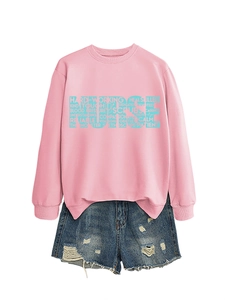 Flat lay of pink nurse sweatshirt with hollow letters and distressed denim shorts