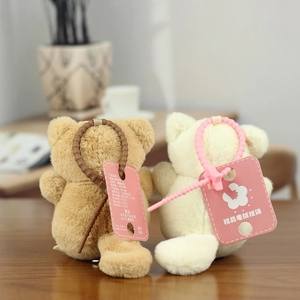 Detail of two 12cm plush bear keychains in brown and white with pearled straps