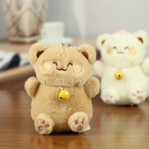 Close-up of cute plush cat keychain with embroidered face details and a yellow bell
