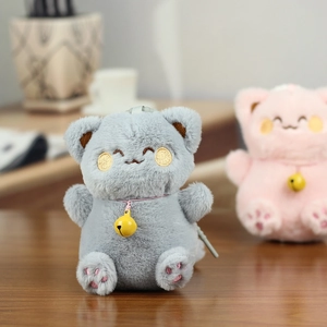 Close-up of grey plush cat keychain with soft faux fur and yellow metal bell