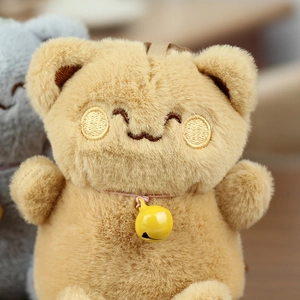 Close-up of plush lucky cat keychain with soft brown fur, embroidered face and yellow bell