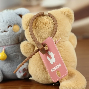 Close-up of cute plush cat keychains with fluffy texture and yellow bell details
