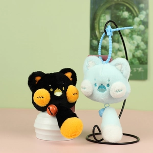 Gros plan de jolis porte-clés chat en peluche avec visages brodés et clochettes