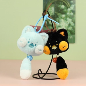 Détail de porte-clés chat en peluche bleu et noir avec clochettes et queues douces
