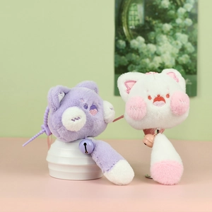 Détail de breloques chat en peluche avec fourrure douce, broderies et clochettes colorées