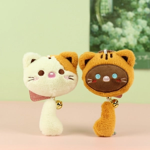 Detailed view of plush cat head keychains with bells and long fluffy tails