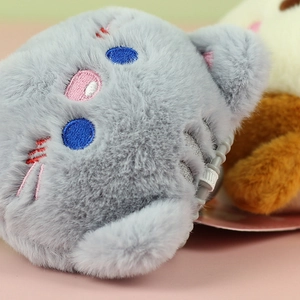 Close-up of soft grey plush cat face with blue eyes and hidden zipper detail