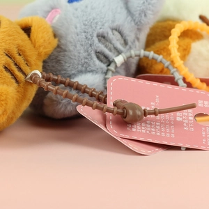 Detail view of pink product tag and beaded security ties on plush cat pendant