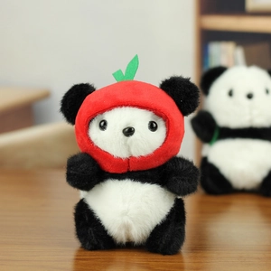 Close-up of cute plush panda keychain wearing a red apple hat with soft fuzzy texture