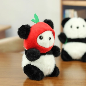 Detail of cute plush panda keychain wearing a red fruit hat with green leaves