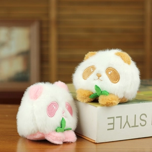 Close-up of cute plush panda charms in brown and pink holding green leaves