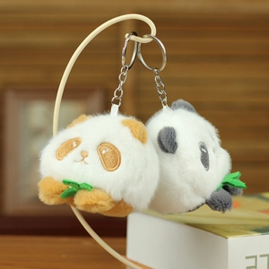 Close-up of plush panda keychains with soft fur and embroidered faces holding bamboo