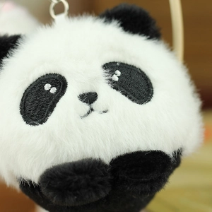Close-up of plush panda keychain featuring soft fur texture and detailed embroidery