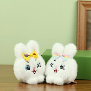 Primer plano de conejitos de peluche blancos con lazos de arcoíris y bordados