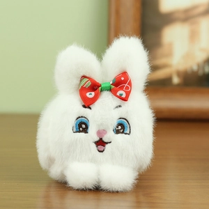 Primer plano de llavero de conejo de peluche blanco con lazo rojo de lunares y bordados