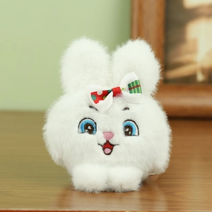 Detalle de llavero de conejo de peluche blanco con bordado y lazo de lunares rojos