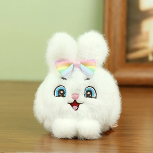 Detalle de llavero de conejo de peluche blanco con bordado y lazo de colores arcoíris