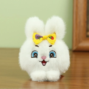 Primer plano de llavero de conejo de peluche blanco con textura suave y lazo amarillo