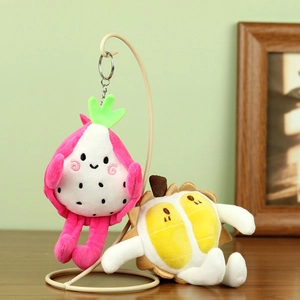 Détail de porte-clés en peluche fruit du dragon et durian suspendus sur un support