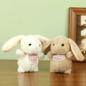 Detail of cute long-eared plush bunny keychains with pink checkered bibs in soft colors