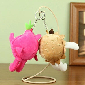 Détail de porte-clés en peluche pitaya et durian sur un support métallique crème