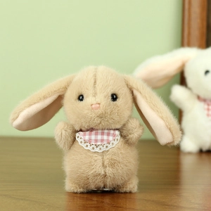 Close-up of cute plush bunny with pink checkered lace bib and soft light brown fur