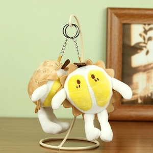Détail de mignons porte-clés en peluche durian suspendus sur un support en métal blanc