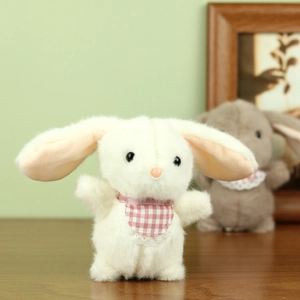 Close-up of white plush bunny keychain with pink checkered lace bib on wooden table