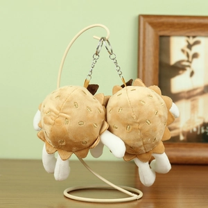Gros plan de pendentifs de fruits en peluche avec broderie dorée et porte-clés en métal