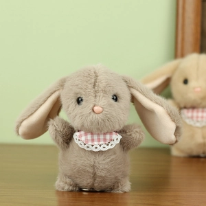 Detailed view of plush rabbit with soft grey fur, long ears and pink lace bib detail